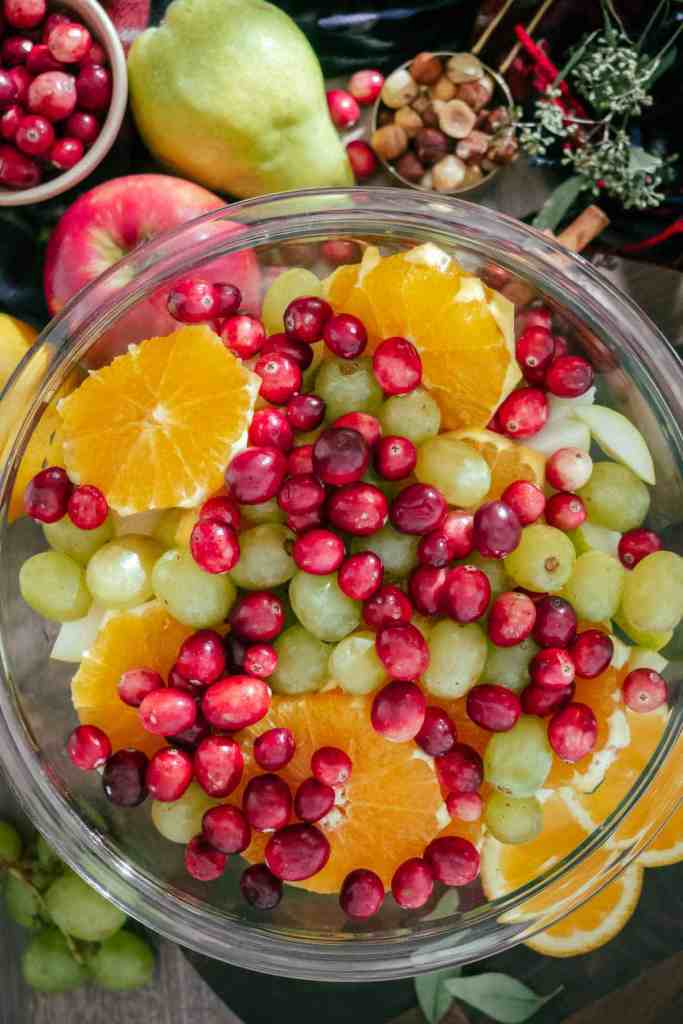 Fruits are tossed together in a large mixing bowl.